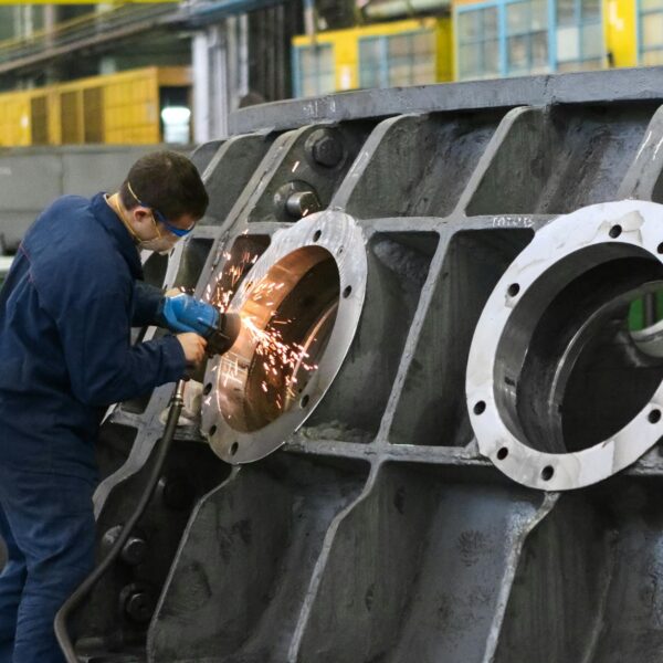 man welding round window frame